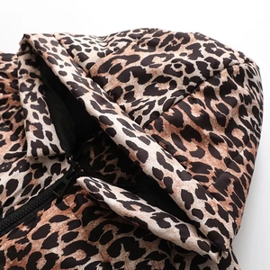 Détail de la veste à capuche léopard avec tissu texturé et fermeture éclair en métal noir