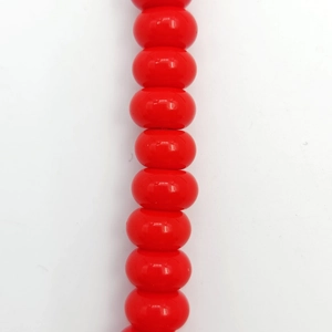 Macro shot of vibrant red 8x5mm glass spacer beads showing high gloss and smooth texture