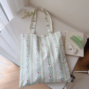 Detailed macro view of the floral stripe pattern and minimalist label on the cotton tote bag