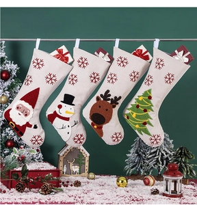Détail de quatre chaussettes de Noël avec motifs Père Noël, Bonhomme de neige et Renne