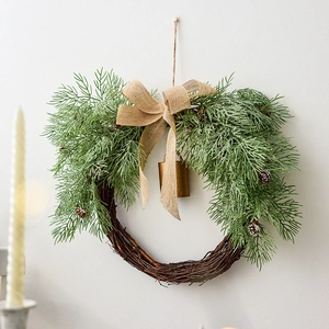 Artificial Christmas wreath with green pine needles, pine cones and a golden bell