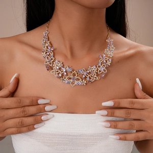 Detail of flower necklace with purple and pink crystals on gold-tone metal chain