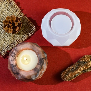 Detail of geometric silicone mold and finished marble texture scented candle on wooden props
