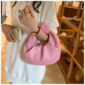 Detail of pink ruched hobo bag with signature knot handle and premium matte texture