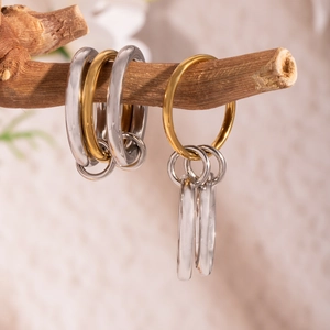 Artistic detail of interlocking gold and silver rings on a natural branch