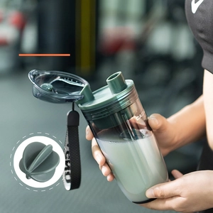 Détail du shaker gris avec couvercle vert et boule de mélange pour boissons protéinées