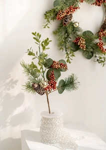 Detail of Christmas greenery stem with red gold berries and pine cone for festive decor