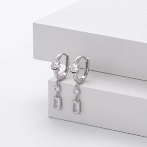 Macro shot of S925 silver huggie earrings with star motifs and rectangle zircon drops
