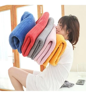 Soft coral fleece towel set in five colors held by a model to show plush texture
