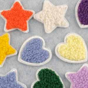 Colorful chenille star and heart patches in assorted embroidery colors on blue fabric