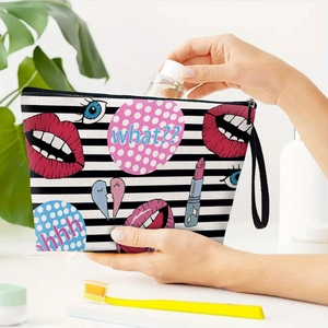 Striped canvas makeup bag with pop art lip prints and black zipper on a vanity