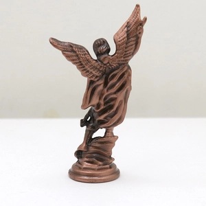 Macro detail of vintage bronze angel wings and feather textures on metal ornament