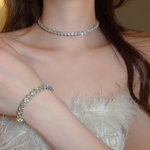 Silver jewelry set detail showing sparkling round crystal necklace and bracelet on model