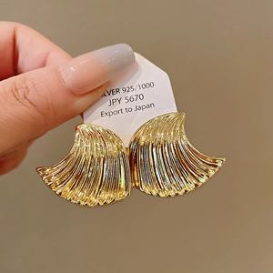 Detail of gold geometric shell earrings with fine wave texture on S925 silver base