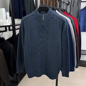 Detailed knit texture of navy cable knit sweater with metallic half-zip and stand collar
