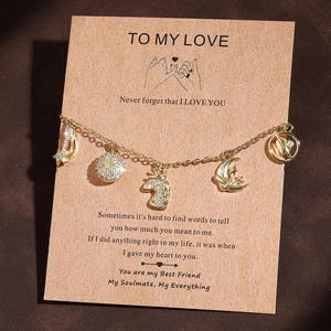 Detail eines goldenen Bettelarmbands mit Einhorn und Mond auf einer Geschenkkarte