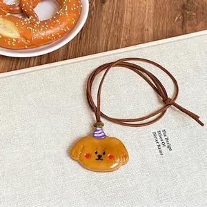 Mignon collier pendentif chien de dessin animé en résine sur table en bois