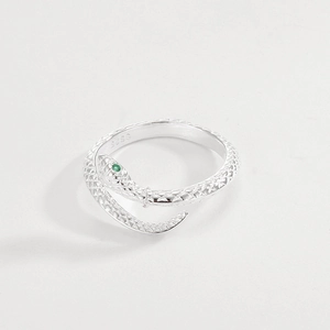 Macro shot of S925 sterling silver snake ring featuring green gemstone eyes and scales