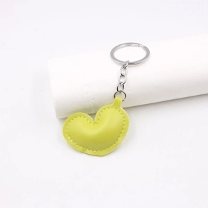 Close-up of yellow-green PU leather heart charm with silver metal keyring and chain