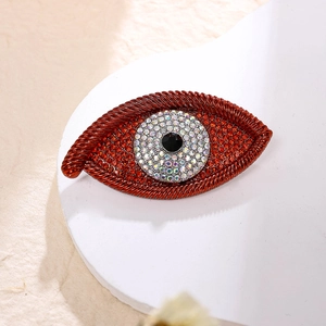 Detailed view of red Evil Eye brooch with sparkling rhinestones and woven texture