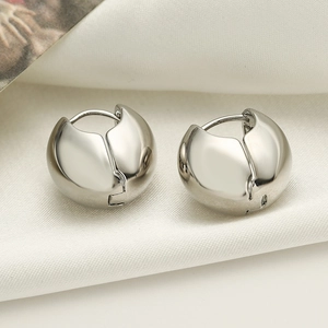 Minimalist thick silver geometric hoop earrings on luxurious white silk background