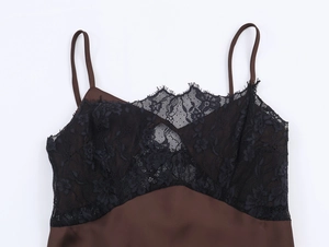 Detail of dark brown satin dress featuring delicate black lace trim at the neckline