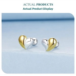 Macro shot of asymmetric heart stud earrings with two-tone finish and screw back