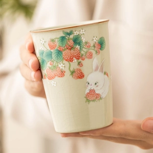 Ru-kiln ceramic teacup with strawberry and rabbit pattern on green crackle glaze surface