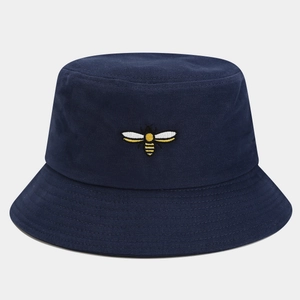 Close-up of a bee embroidery detail on navy blue canvas bucket hat with fine texture