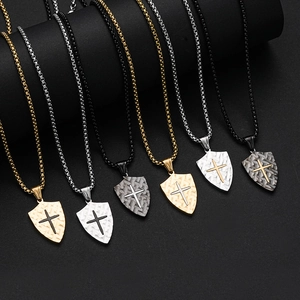 Detailed display of shield cross pendants in gold, silver, and black metal finishes