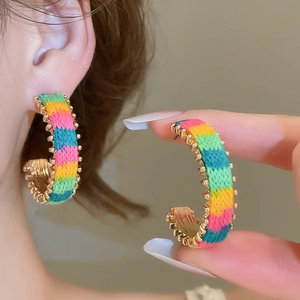 Detailed close-up of rainbow knit C-shaped earrings with delicate gold bead accents