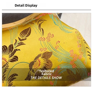 Macro detail of Chinese embroidery on yellow silk fabric with elegant metal frame