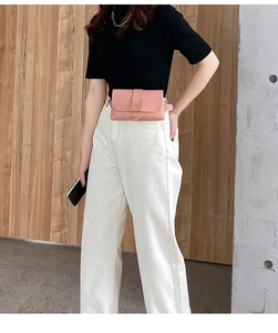 Detail of pink PU leather belt bag with a golden ring buckle worn by a model