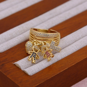 Macro shot of 18K gold ring featuring zircon-encrusted heart, cross, boy and girl charms