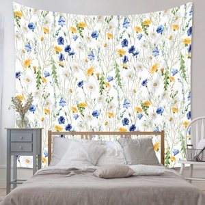 Detail of bohemian tapestry showing watercolor wildflower prints on soft fabric texture