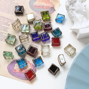 Close-up of colorful vintage square glass beads with gold frosted edges for DIY jewelry