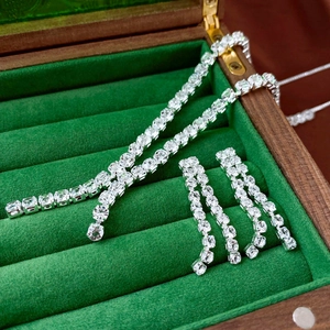 Macro view of zircon tassel necklace and earrings set in a green velvet jewelry box