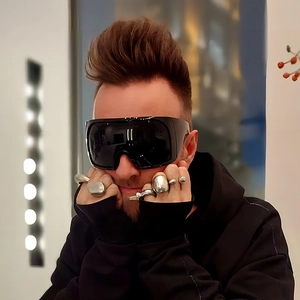 Close-up of wrap-around oversized black sunglasses paired with metallic rings