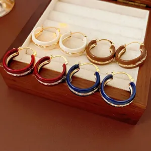 Vintage geometric enamel hoop earrings in four colors displayed in a velvet box
