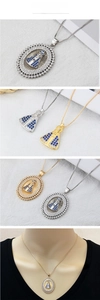 Détail du pendentif Nossa Senhora Aparecida avec zircons bleus sur chaînes or et argent