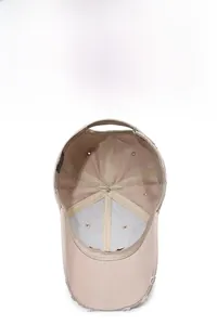 Detail view of the six-panel structure and breathable holes inside this beige baseball cap