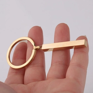 Detailed view of polished gold stainless steel bar pendant held in hand for keychain custom engrav