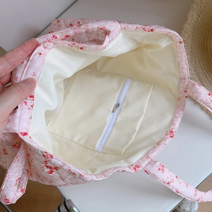 Detailed interior of pink floral tote bag showing spacious lining and zipper pocket