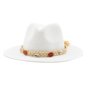 Close-up of white woven straw fedora with decorative shell and amber resin bead band