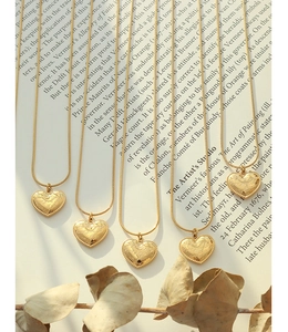 Detail of vintage heart pendants with I love you engraving on golden snake chains