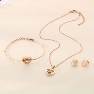 Detail of rose gold jewelry set featuring hollow heart pendants with love engraving