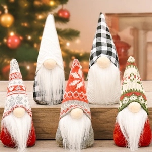 Set of five festive Christmas gnomes with knitted hats on a wooden table with lights