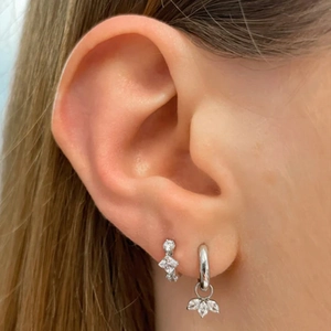Close-up of S925 sterling silver hoop earrings with zircon flower pendant on female ear