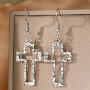 Silver hammered cross drop earrings with large hollow design on a jewelry display box