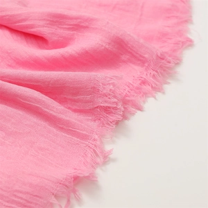 Close-up of pink cotton linen scarf showing soft crinkle texture and fringe edges